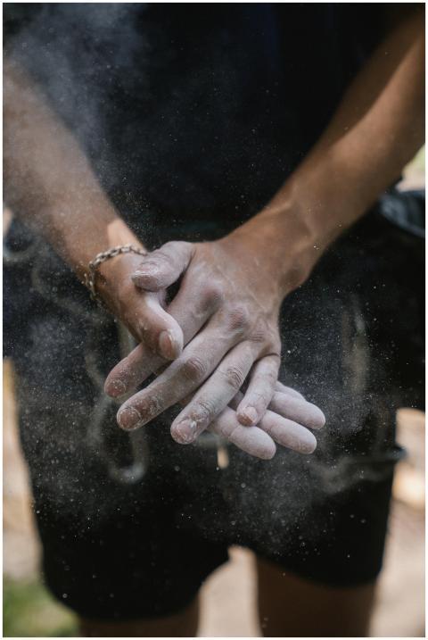 Close-up of a rock climber clapping chalked hands