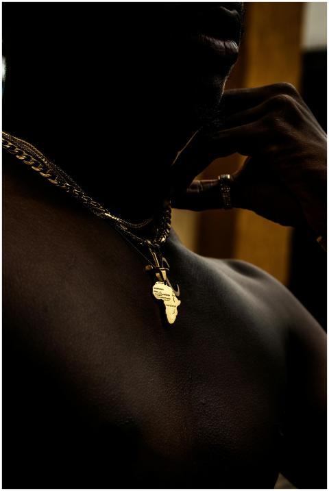 Close-up of a shirtless man wearing a gold necklac