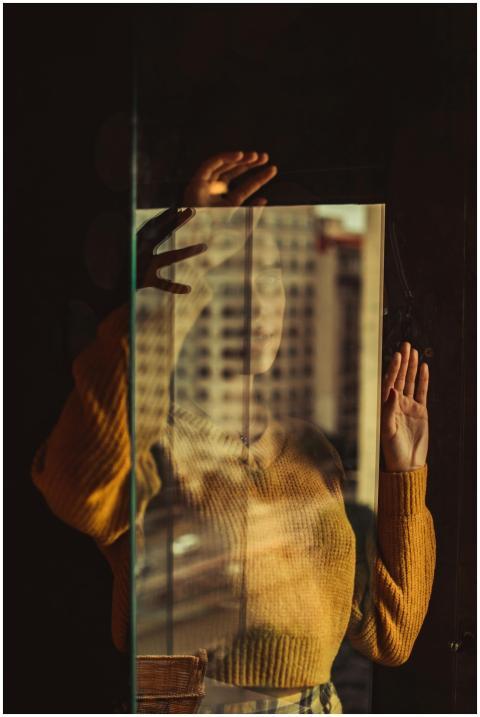 Artistic portrait of a woman reflected in glass, c