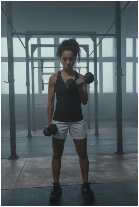 African American woman performs bicep curls with d