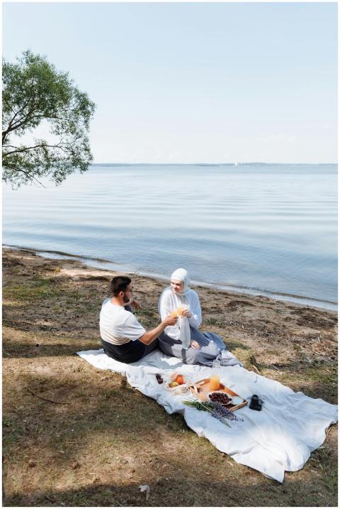 A couple enjoying a romantic picnic by the lake wi