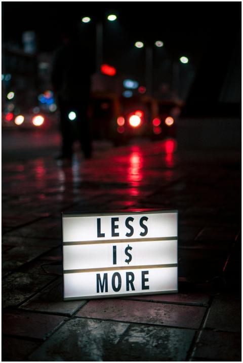 Minimalist lightbox sign reading 'Less is More' on