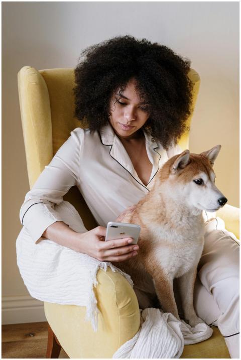 Woman with afro hair sitting in an armchair at hom
