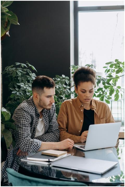 A man and woman working together on a laptop in a
