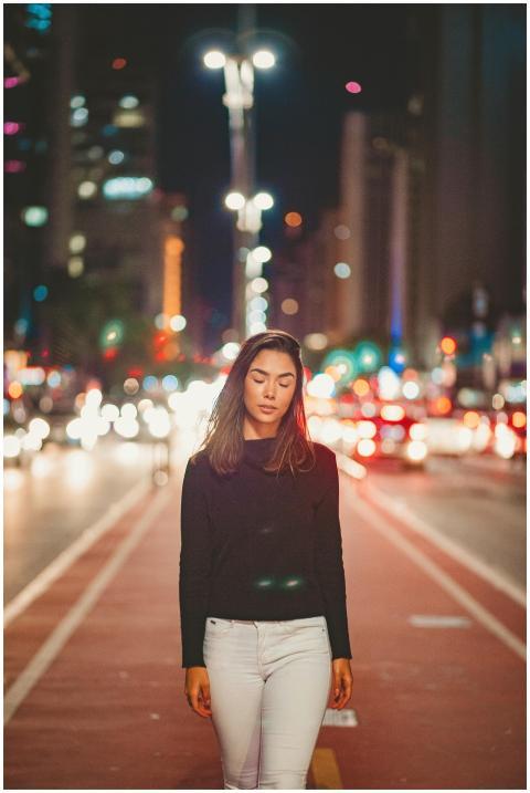 Elegant woman walking at night on an illuminated c