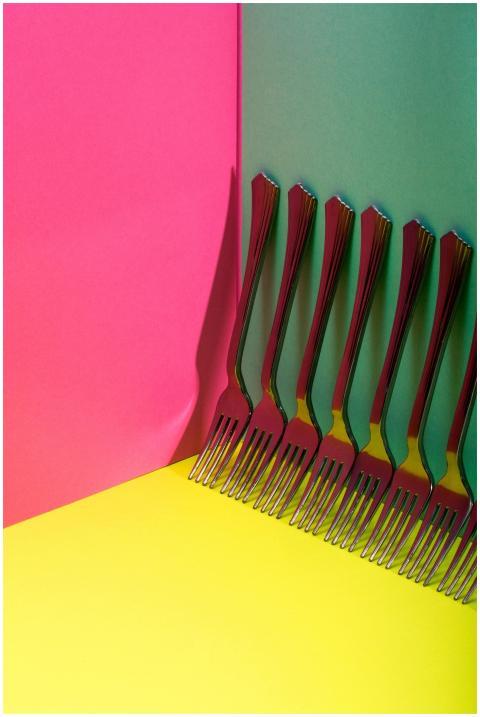 Vibrant, artistic display of forks against a pink