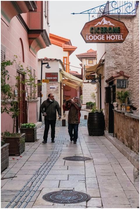 Two men walking down a picturesque street with the