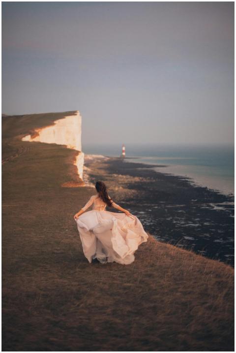 Bride in flowing dress on a dramatic cliff overloo