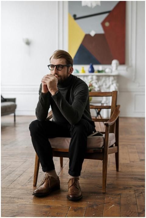 Thoughtful man sitting in a chic living room, embo