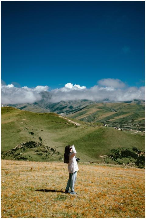 A woman taking photos of a beautiful mountainous l