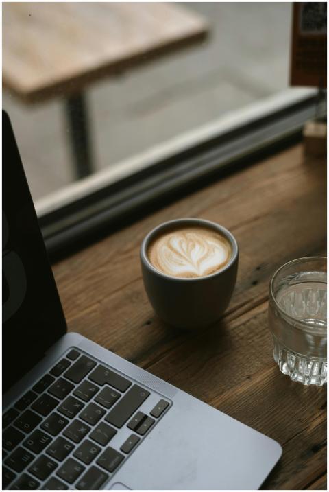 A cozy café scene with a laptop and latte on a woo