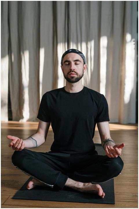 A man practices meditation in a yoga studio sittin