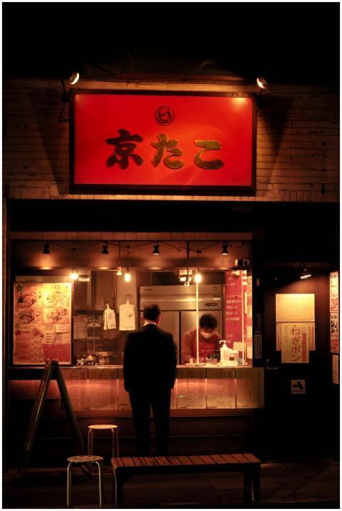 An adult male at a Japanese street food stall in T