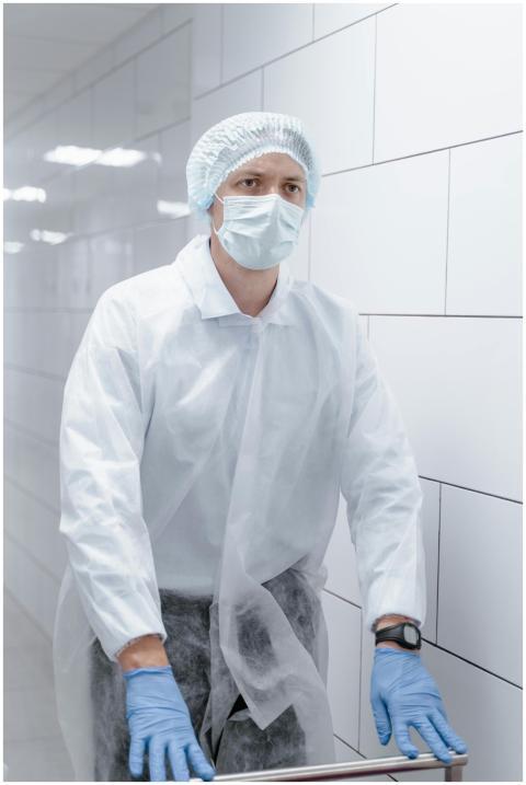 Healthcare worker in PPE with mask and gloves ensu