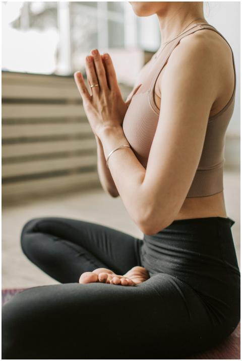 A woman in a yoga pose meditating indoors. Focused