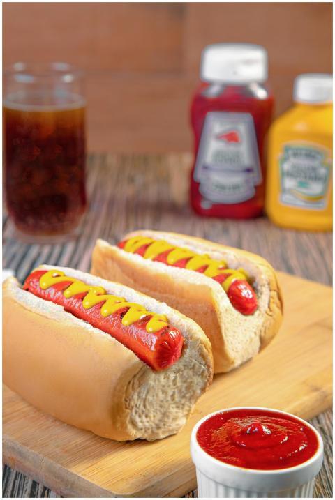 Two hot dogs with ketchup and mustard on a board,