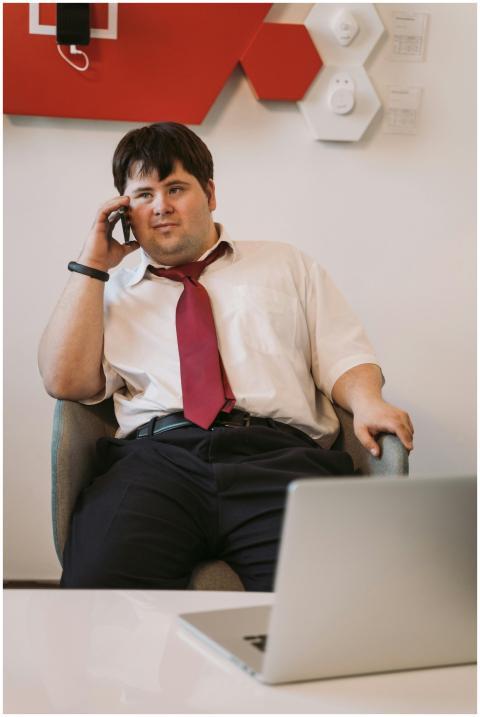 A man in a shirt and tie talks on his cellphone wh