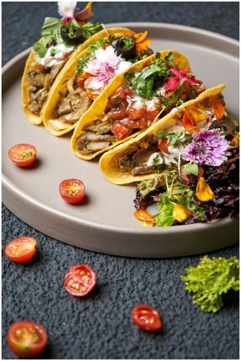Close-up of gourmet tacos garnished with fresh her