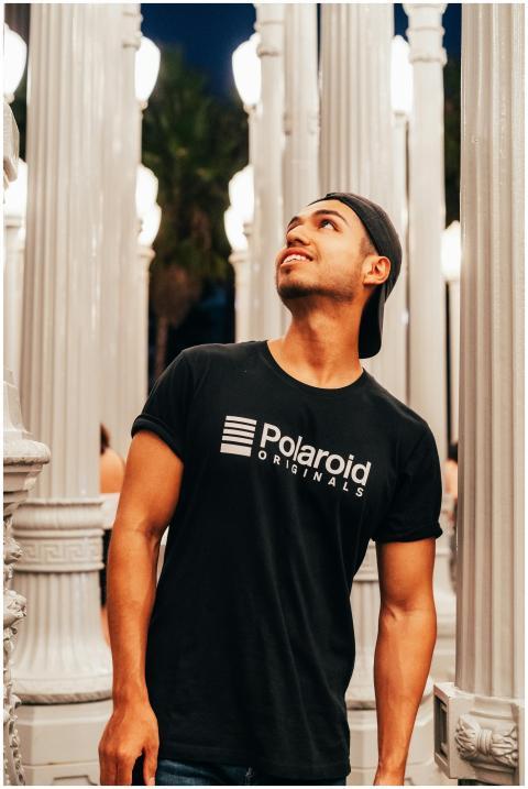 Man in casual attire poses among illuminated urban