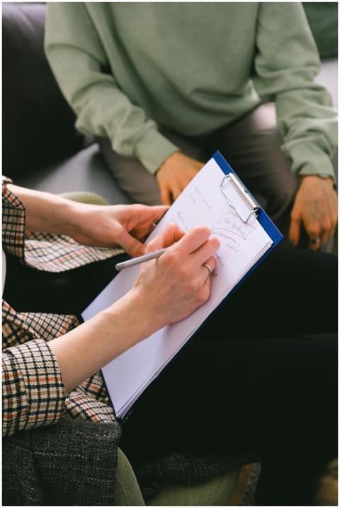 Close-up of a therapist taking notes during a sess