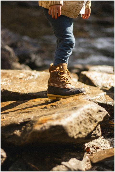 Young child exploring nature in sturdy boots, stan