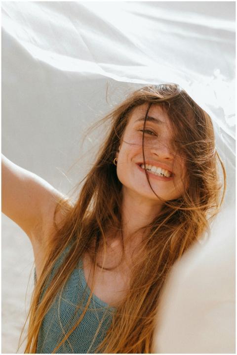 Smiling woman with long hair enjoys a windy day ou