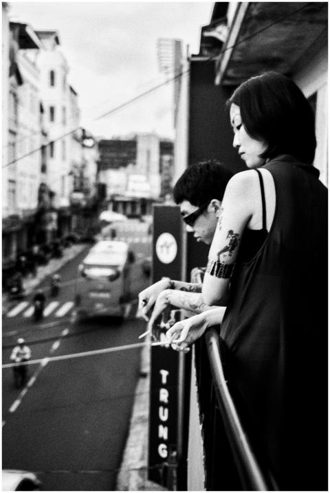 Black and white urban scene with people on a balco
