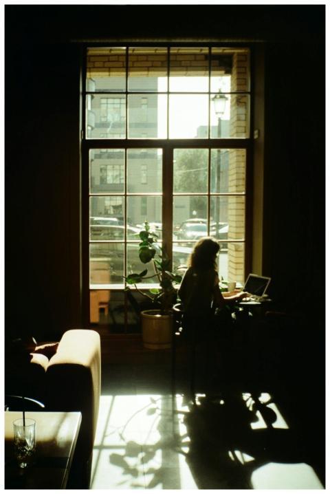 Silhouette of a woman using a laptop in a cozy Mos
