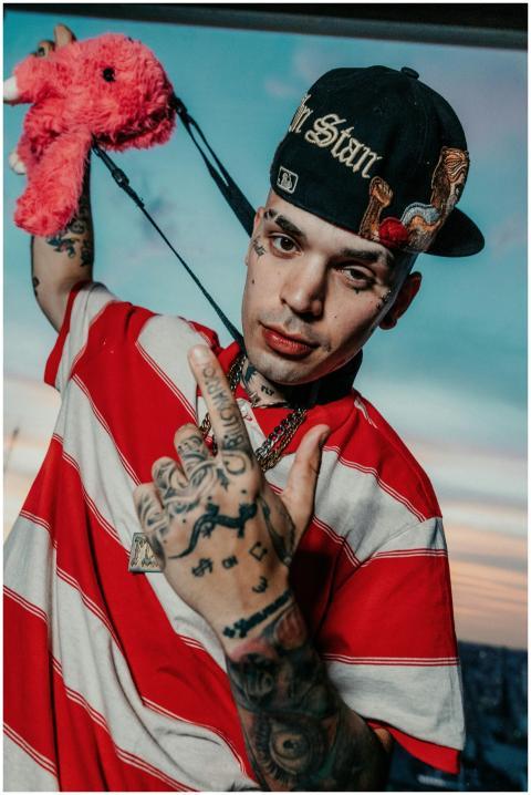 Young man with tattoos and streetwear posing with