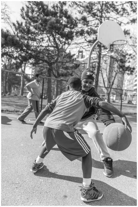 Two boys playing intense basketball on an outdoor