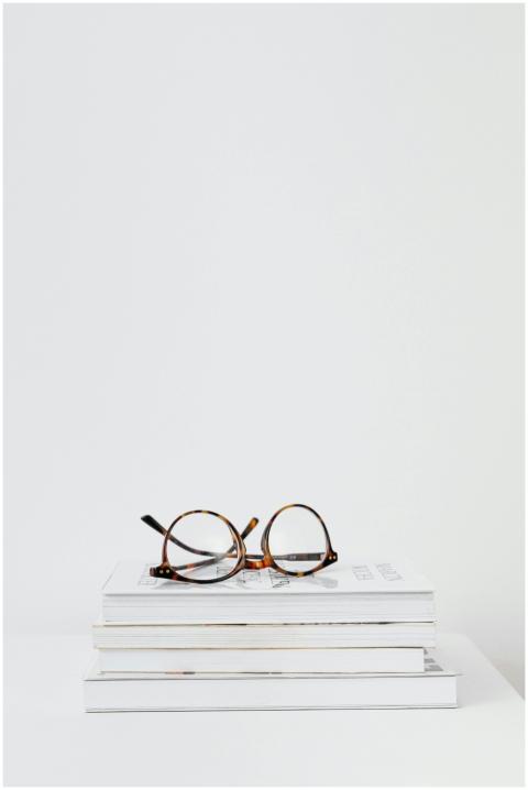 Minimalist image of round eyeglasses atop a stack
