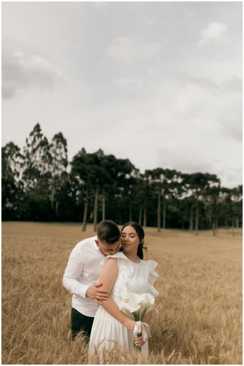 A couple embraces in a wheat field, symbolizing lo