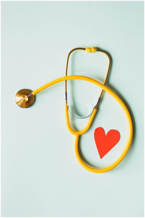 Yellow stethoscope arranged with a red heart cutou