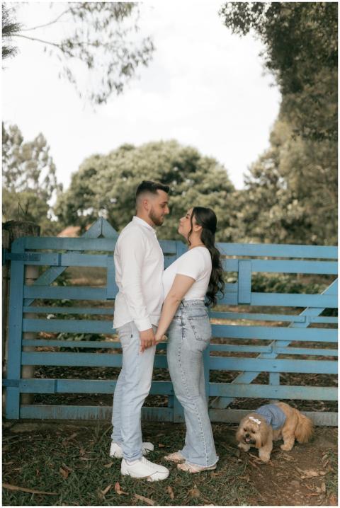 A couple holds hands near a blue gate with their d
