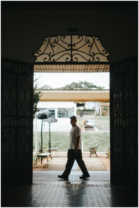 A silhouette of a man walking through an ornate ga
