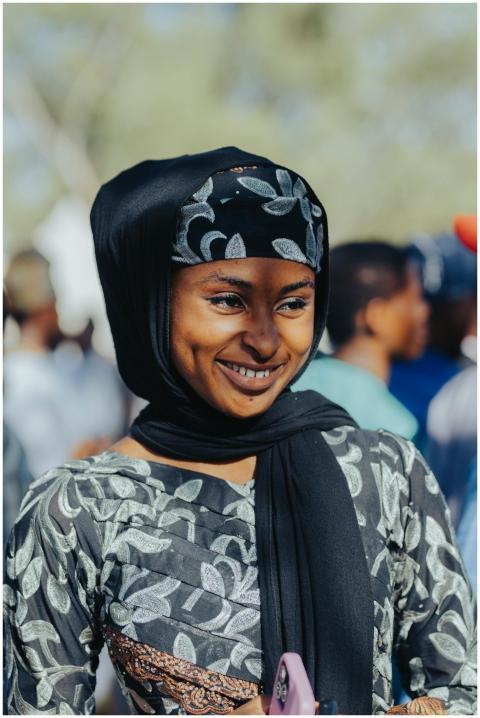 A joyful woman in traditional clothing smiles duri