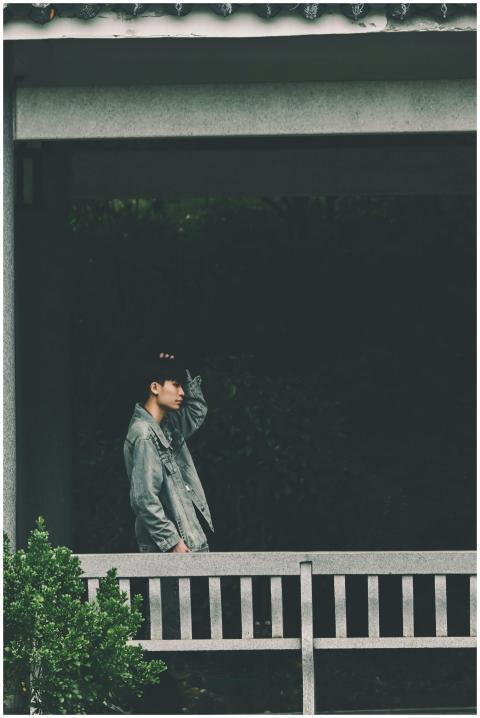 Side profile of a young man in urban attire standi