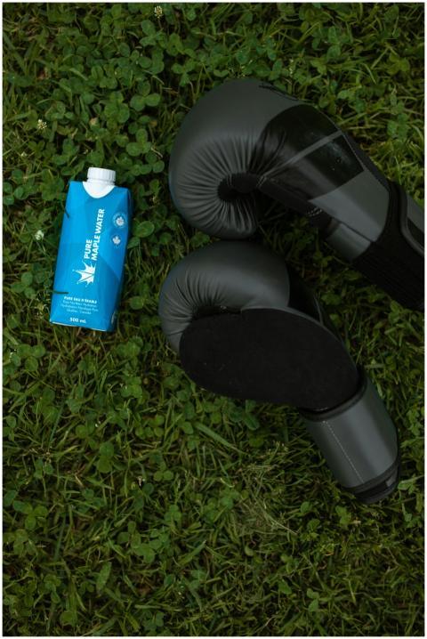 Boxing gloves and Pure Maple Water carton on grass