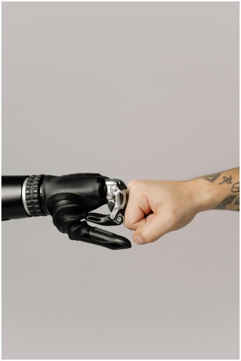 Close-up of a human fist bumping a prosthetic hand