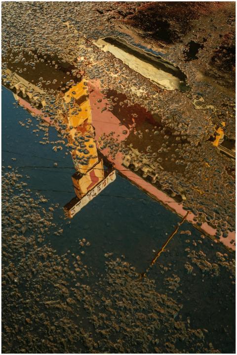 A vibrant reflection of a building in a water pudd