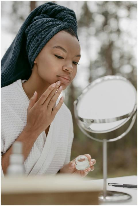 A woman applying face cream during a calming beaut