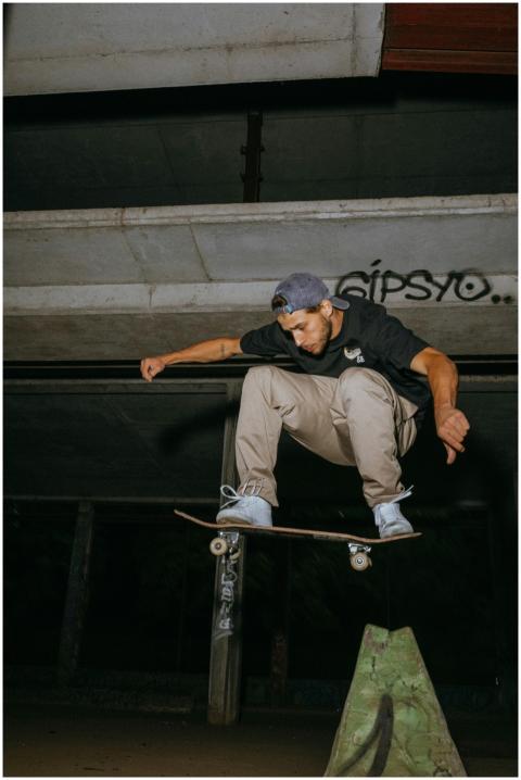 Man performing a skateboard trick indoors under an