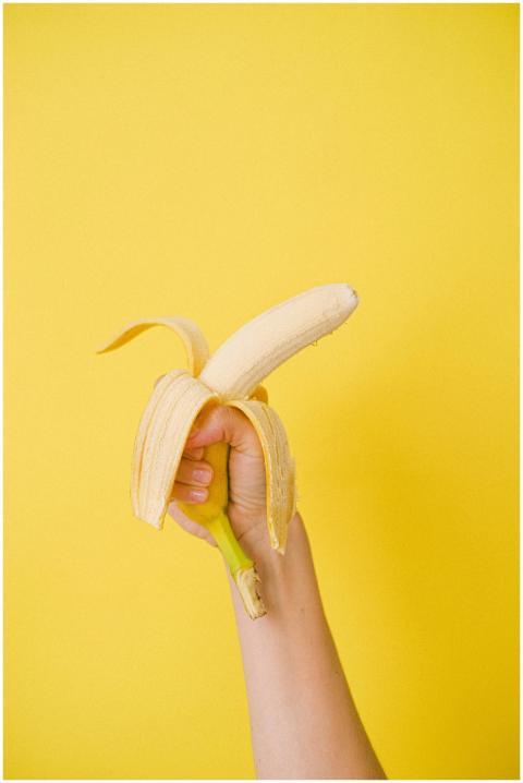 Crop anonymous female holding half unpeeled ripe o