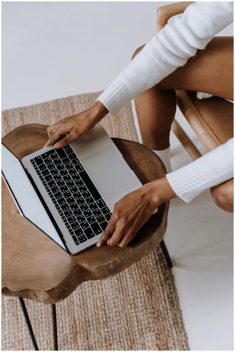Close-up of a woman typing on a laptop indoors, fo