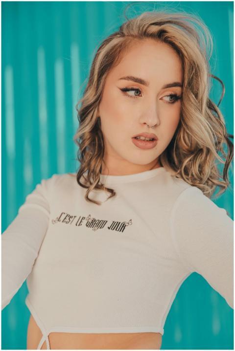 Chic portrait of a blonde woman posing against a v