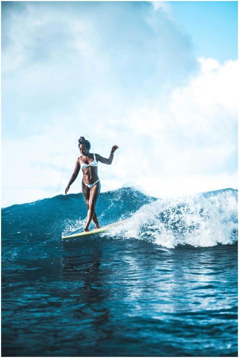 A dynamic image of a woman surfing a wave, capturi