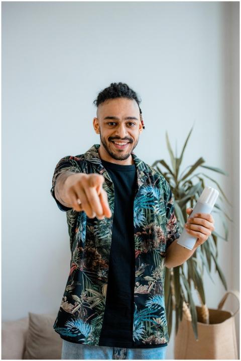 Cheerful young man pointing at camera with a smile