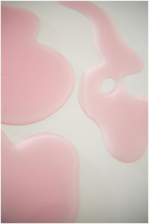 Abstract close-up of pink liquid forms on a white