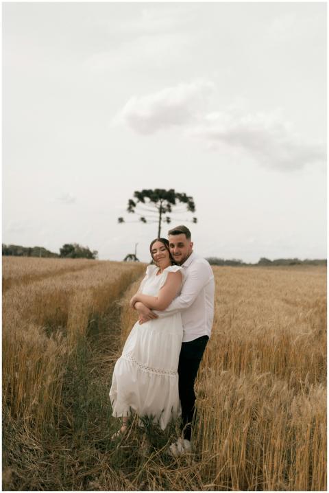 A loving couple embraces in a serene wheat field u