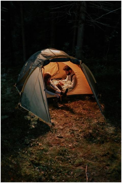 A couple enjoying a cozy evening inside a tent in